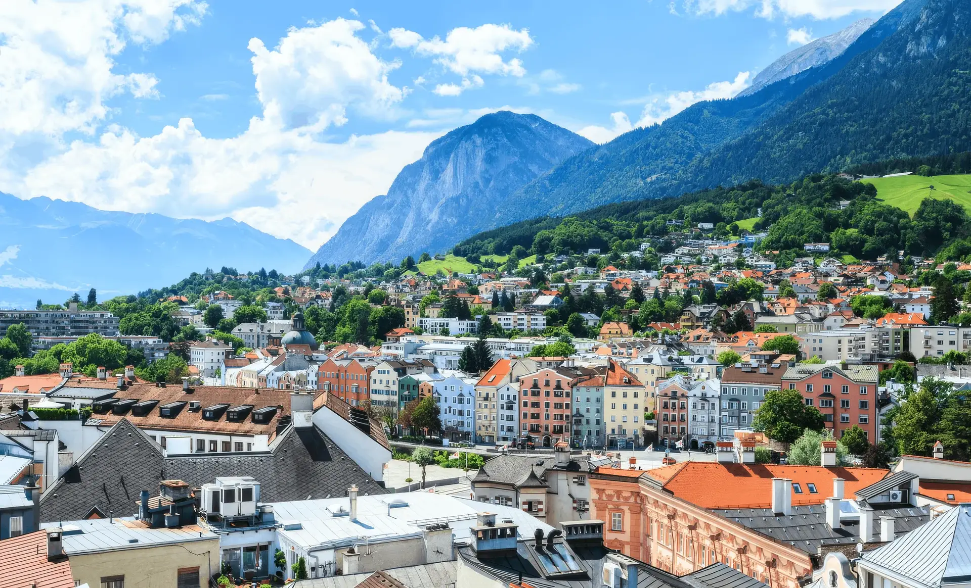 Uitzicht over de daken van Innsbruck in de zomer met de omliggende bergen