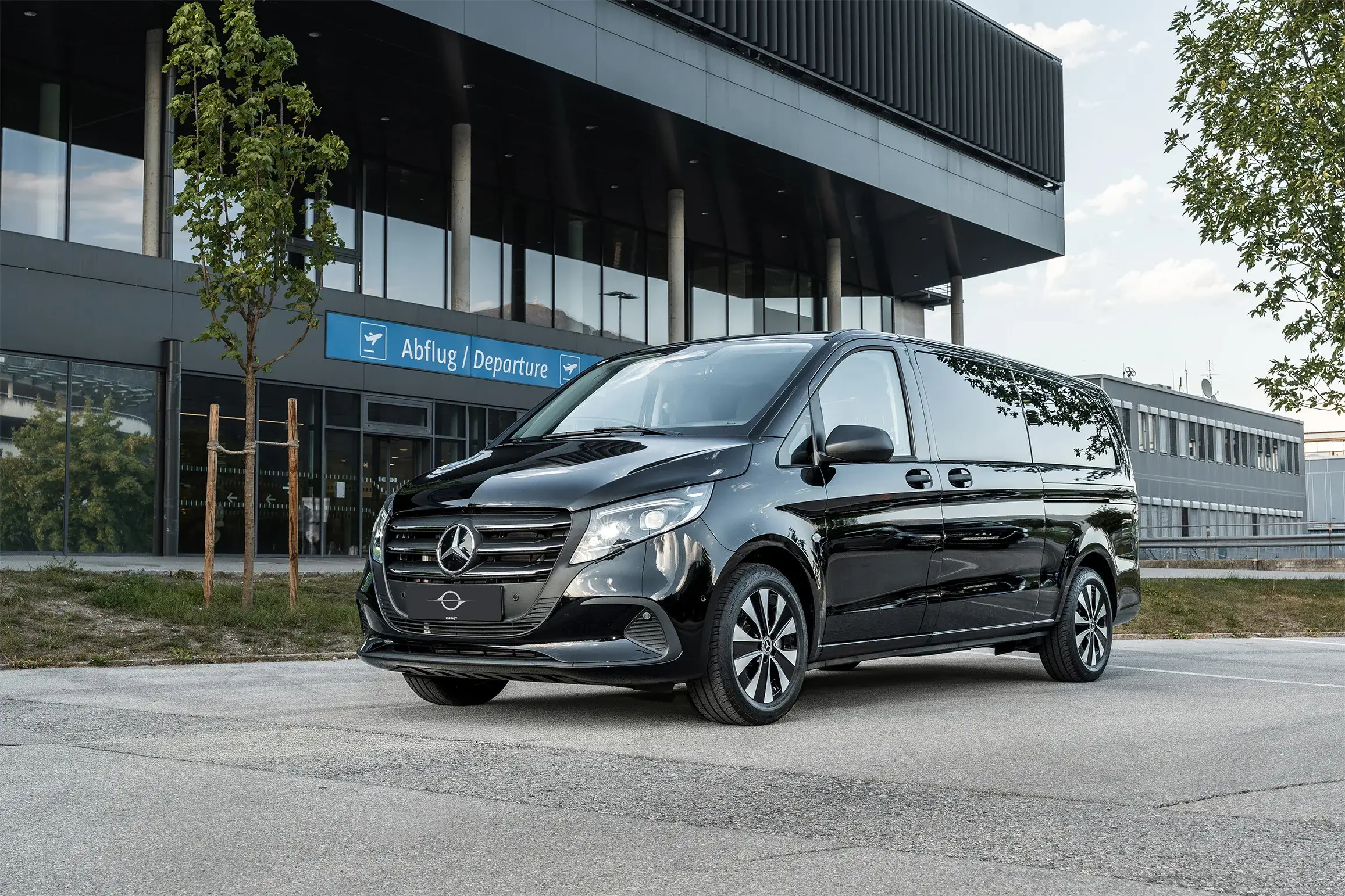 Schwarzer Mercedes Vito vor dem Abflugbereich des Flughafens Innsbruck