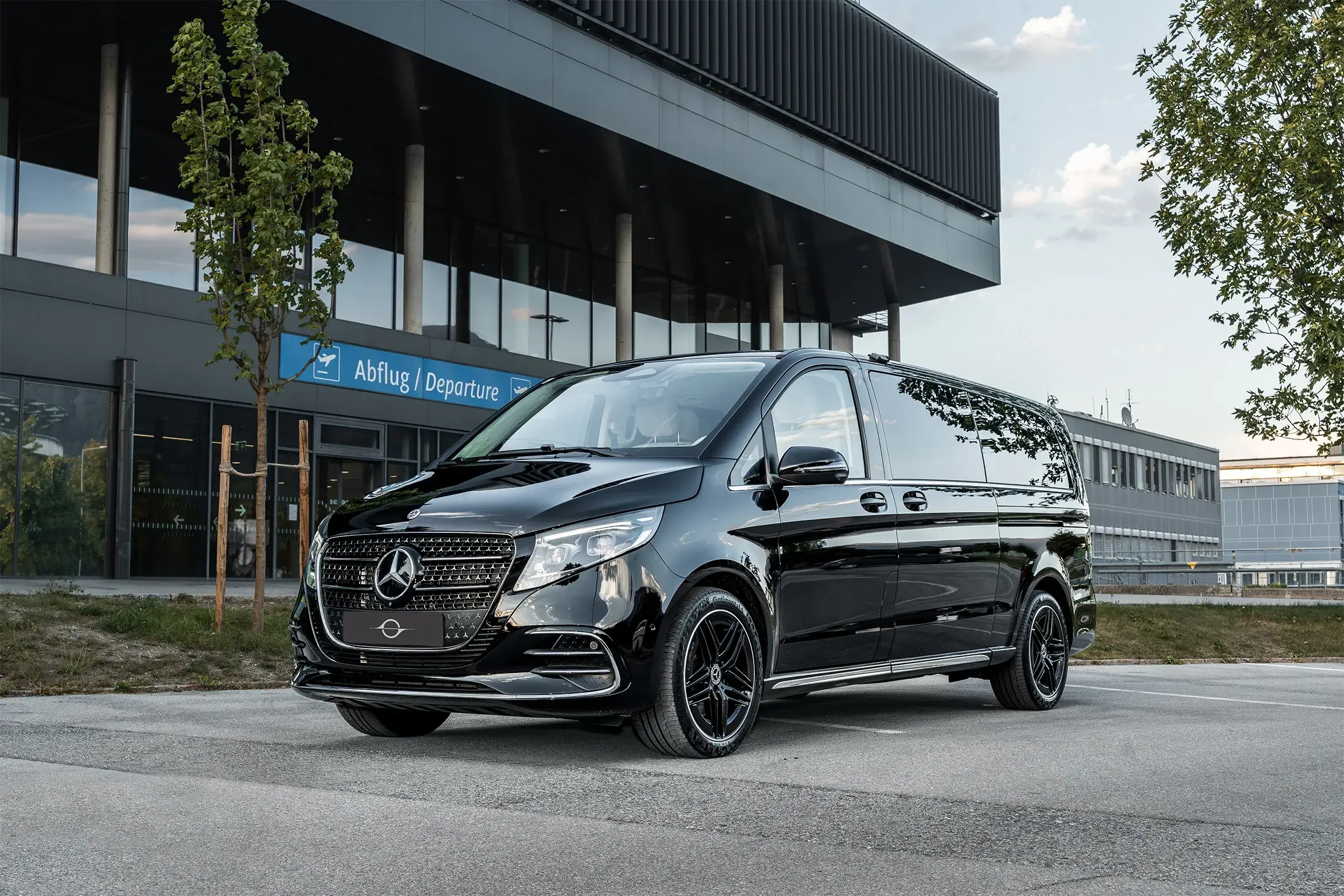 Schwarze Mercedes V-Klasse vor dem Abflugbereich des Flughafens Innsbruck